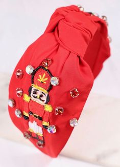 This red fabric headband is adorned with embellishments featuring a Nutcracker and has rhinestones accents with a top knot! Nutcrackers are trending this year and grab it before it's gone Embellished Headband, Festival Headband, Holiday Headbands, Holiday Accessories, Red Headband, Embellished Headbands, Christmas Headband, Fabric Headbands, J Cole