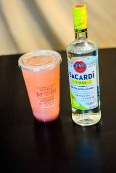 a bottle of bacardi next to a plastic cup on a black countertop