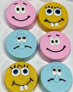 four different colored cookies with faces on them