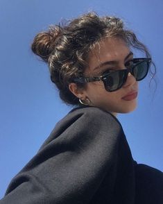 a woman with sunglasses on her head is taking a selfie in front of the blue sky