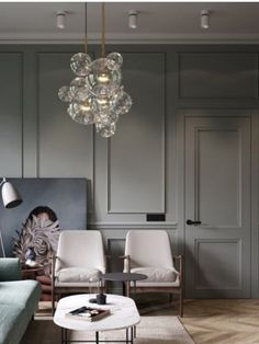 a living room filled with furniture and a chandelier hanging from the ceiling above