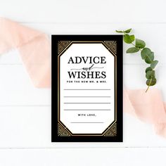 a black and gold wedding advice card with greenery on the table next to it