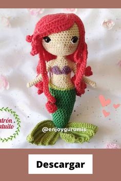 a crocheted mermaid doll is sitting on a bed with the caption descargar