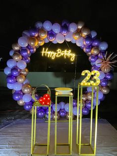 two stools are in front of a balloon arch that says happy birthday and the number twenty