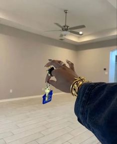 a person is holding keys in an empty room