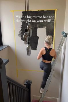 a woman is climbing up the stairs in her house and has an advertisement on the wall behind her