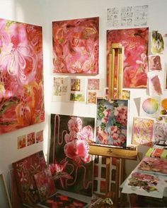 an artist's studio with many paintings on the wall