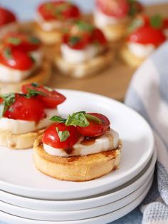 small appetizers with tomatoes and mozzarella on them are sitting on plates