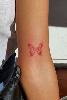 a woman's arm with a butterfly tattoo on the back of her left arm