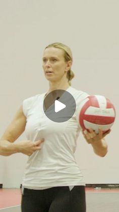 a woman holding a red and white volleyball