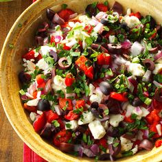 a large bowl filled with lots of different types of food on top of a table