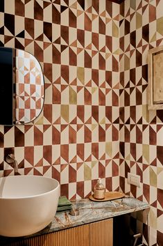 a bathroom with a sink, mirror and patterned wall paper on the walls behind it