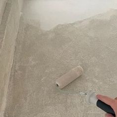 a person is using a roller to paint the floor