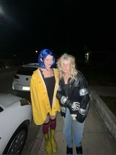 two women standing next to each other near a car