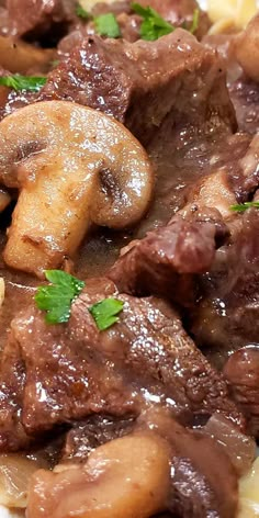 a close up of food on a plate with broccoli and mushrooms in sauce