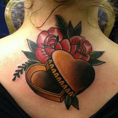 a woman with a heart tattoo on her back neck and flowers in the center is shown