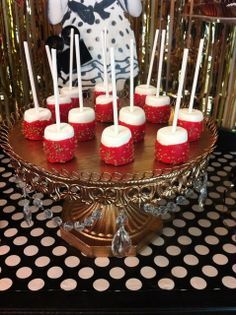 there is a cake with white frosting and red icing on the top, surrounded by polka dots