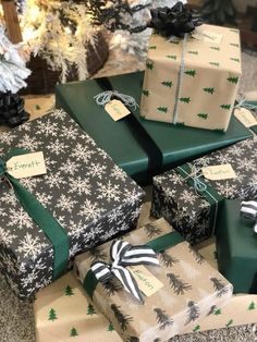 several presents wrapped in black and white paper with green bows