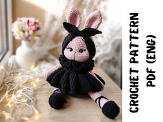 a crocheted bunny doll sitting on a table next to a window