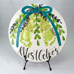 a white plate with green and blue handprints on it that says, mistere's