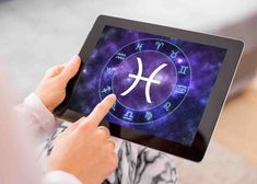 a person holding an electronic device with zodiac signs on the screen in their hands,