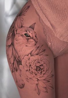 a woman's thigh with a cat and flowers on it