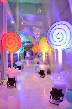 an indoor party with balloons, lights and decorations on the floor in front of it