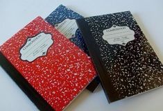 two notebooks sitting side by side on top of a white table with black and red covers