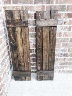 two wooden doors sitting next to each other on a brick wall