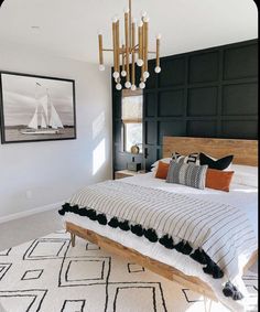 a bedroom with a bed, chandelier and pictures on the wall above it