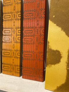 three different colored books sitting on top of a white shelf with yellow and red covers