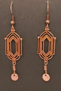 Art Deco Style Dangle Earrings are metal stampings in antique copper tone with elegant surface detail. There is an etched copper tone lentil dangle. Earrings dangle from ball and coil ear wires in antique brass tone. A Takeen Arts original. Designed and created by TLP and staff for Takeen Arts. Item E875. Bohemian Antique Gold Copper Earrings, Vintage Bronze Earrings With Oxidized Finish, Bronze Vintage Earrings With Oxidized Finish, Vintage Copper Dangle Jewelry, Antique Gold Metal Earrings With Antique Finish, Antique Finish Copper Dangle Earrings, Antique Finish Copper Drop Earrings, Ornate Copper Jewelry With Antique Finish, Bronze Antique Finish Drop Earrings