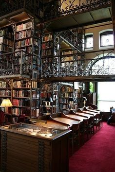 an old library with many bookshelves and tables