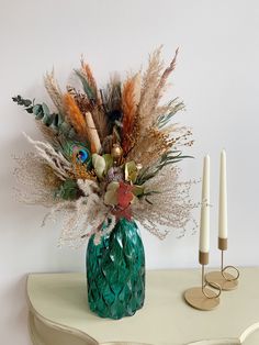 a vase filled with lots of different types of flowers on top of a white table