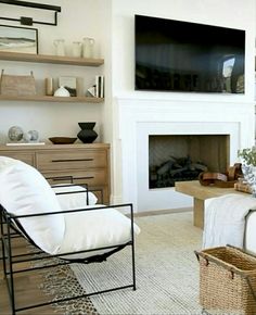 a living room filled with furniture and a flat screen tv mounted on the wall above a fire place