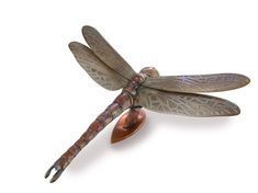 a metal dragon figurine sitting on top of a wooden stand with its wings spread