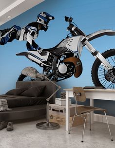 a room with a motorcycle mural on the wall and a couch in front of it