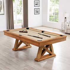 a pool table in the middle of a living room with two billiards on it