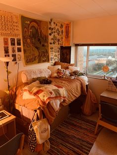 a bed room with a neatly made bed next to a large window and a painting on the wall