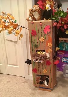 a cardboard box filled with stuffed animals and flowers on the floor next to a door