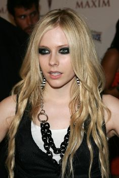 a woman with long blonde hair and black eyeshadow, posing for the camera