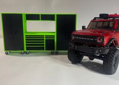 a red toy truck parked next to a green cabinet