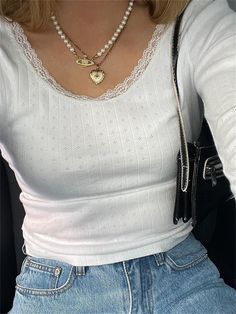 a woman sitting in the back seat of a car wearing a white shirt and jeans