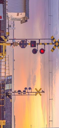 an intersection with traffic lights and street signs in the foreground, at sunset or dawn