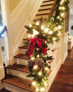 stairs decorated with christmas lights and pine cones