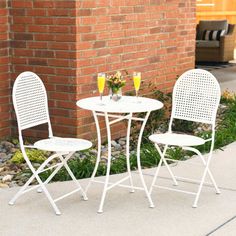 two white chairs and a table with drinks on it