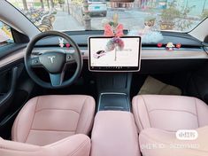 the interior of a car with pink leather seats and an electronic display on the dashboard