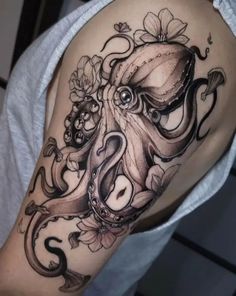 an octopus with flowers on it's arm is shown in black and grey ink