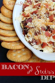 bacon and cheese dip in a white bowl surrounded by crackers on a black table