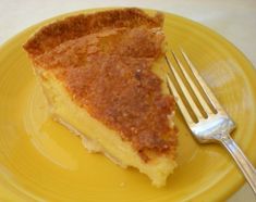 a piece of pie on a yellow plate with a fork